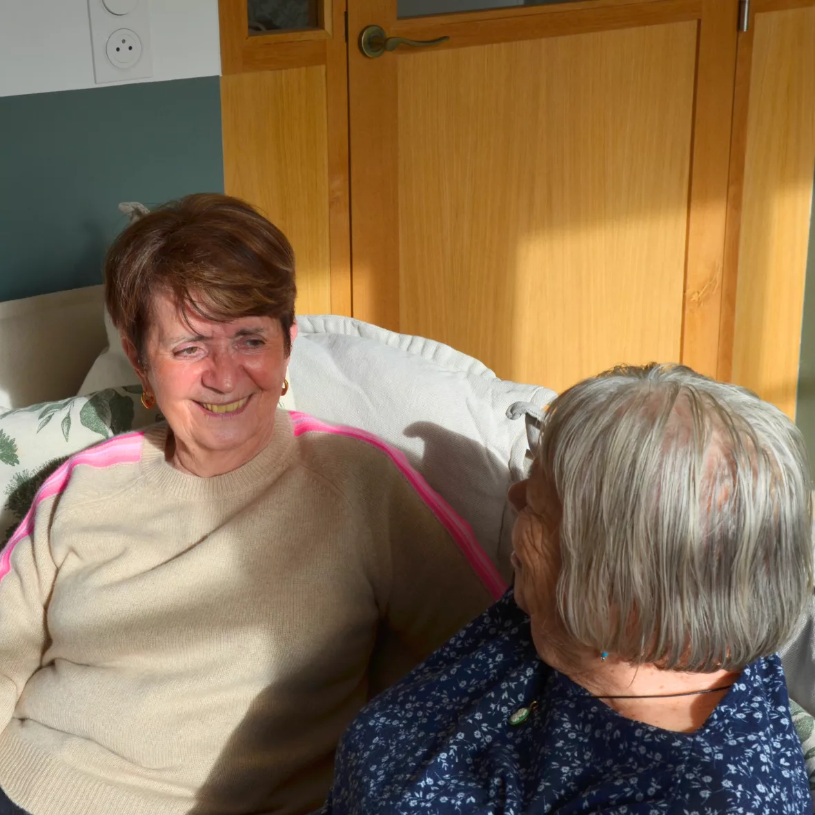 Deux femmes âgées dans un appartement partagé souriants